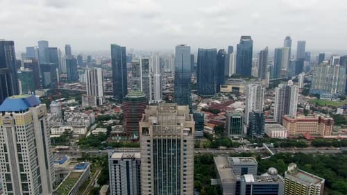 Drone flying over skyscrapers in Jakarta city, Indonesia. Aerial forward
