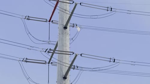 An electrical energy transmission tower and the full moon in the background and the cables can be se