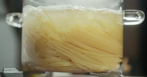 Spaghetti Boiling in a Transparent Saucepan Filled with Bubbling Hot Water Pasta is Cooking in a
