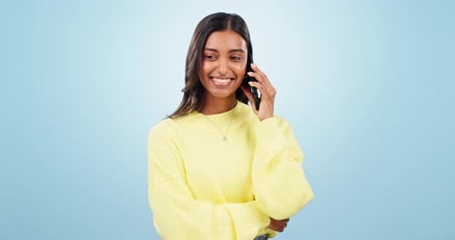 Phone call, talking or happy Indian woman in studio on blue background for communication or chat