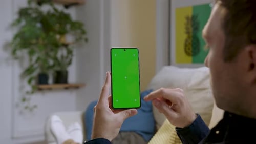 Man's Finger Scrolling On Mobile Phone With Green Screen - Chroma Key. - close up shot