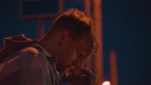 Young Person Pondering Quietly Beneath Gentle City Street Lighting Youthful Individual Reflecting