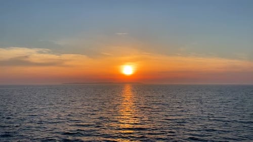 Sonnenuntergang über dem ruhigen, nebligen Meer