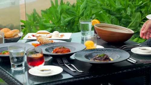 A Waiter Attends to a Table at a Restaurant By the Coast
