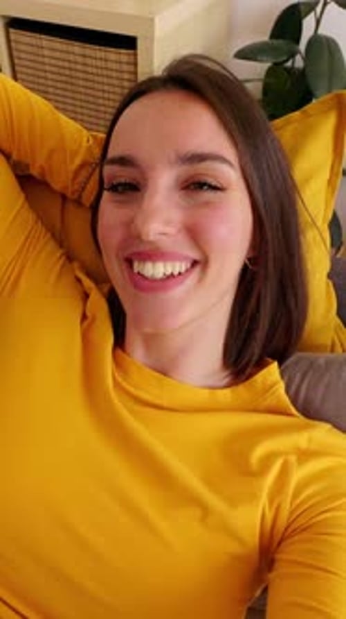 Smiling Woman Lying on Couch in Bright Home