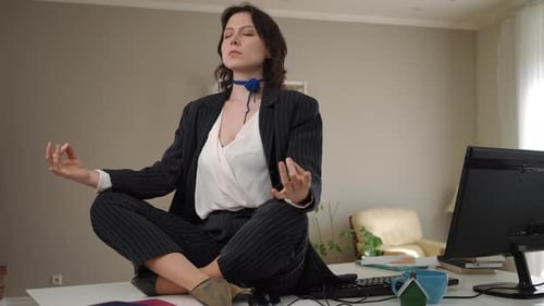 Businesswoman Meditating in Lotus Position on Her Office Desk