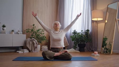 Senior Woman Practicing Yoga in Brightly Lit Room