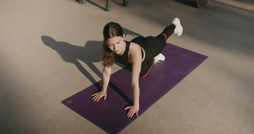 Woman Exercising Outdoors on Yoga Mat on Sunny Day