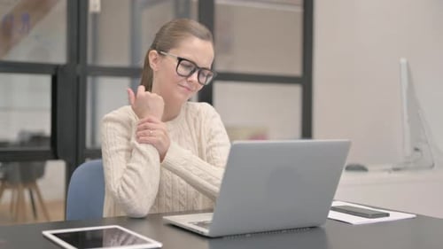 Young Woman having Wrist Pain in Office