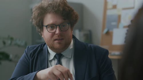 Businessman Discussing Ideas with Colleague during Meeting in Office
