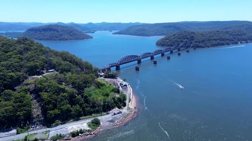 Drone aerial landscape of boat travelling through water inlet channel at Hawkesbury River Railroad