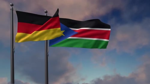 Waving Flags of Germany and South Sudan Against Cloudy Sky