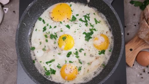 Four Fried Eggs Cooking in a Pan