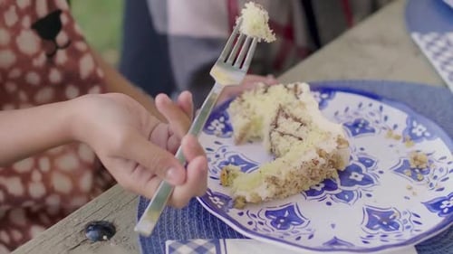 Close Up Girl Eating Cake at Picnic Table 89 Years