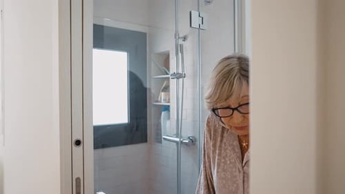 Senior Woman Walks with Walker and Nurse Assistance