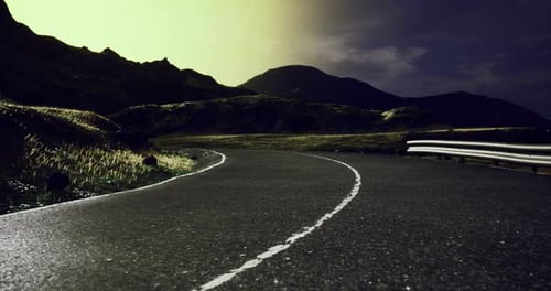Winding Road Through Mountains Illuminated By Moonlight at Night