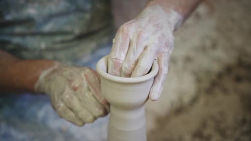 Potier travaillant une pièce en argile blanche