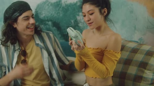 Young Couple Taking Selfie with Instant Camera Indoors