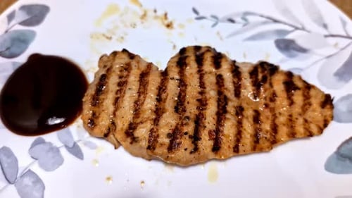 Expertly Grilled Meat Served on a Plate With a Side of Barbecue Sauce - Close Up