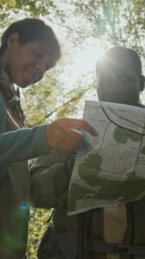 People Viewing Map in Sunny Forest