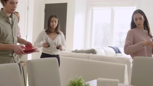 Family and Friends Setting the Table in Modern Home
