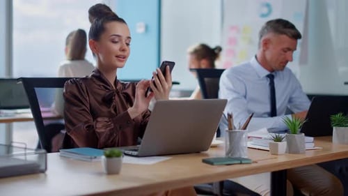 Attractive Businesswoman Talking on Mobile Phone with Client in Office. Smiling Female