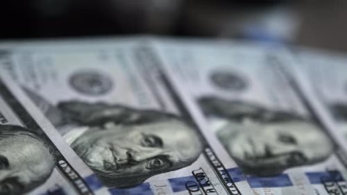 Close-up slow motion shot of 100 dollar bills fanned out on table. Background of money.