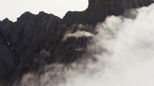 Über den Wolken: Aufstieg der Drohne zum Berggipfel an einem sonnenbeschienenen Tag