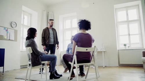 Adults Seated in Circle in Bright Room
