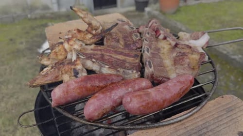 Sausages Beef Chicken And Pork Being Cooked In Small Grill In The Yard