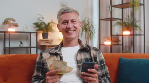 Smiling Happy Caucasian Man Counting Money Euro Cash Use Smartphone Income Salary Lottery Game Win