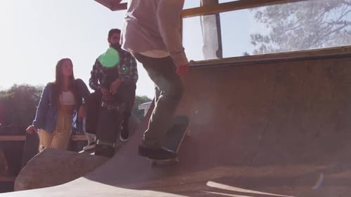 Video of happy diverse female and male skateboarders in skate park