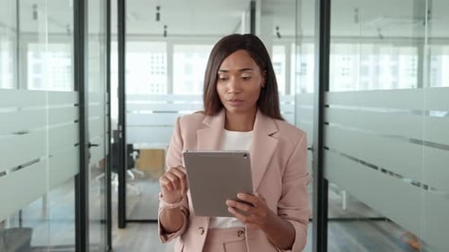 Young African American Business Woman Manager Using Tablet in Office Thinking