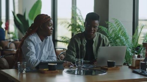 Intelligent Black Businesspeople Discussing Future Opportunities Over a Cup of Coffee in the Cafe