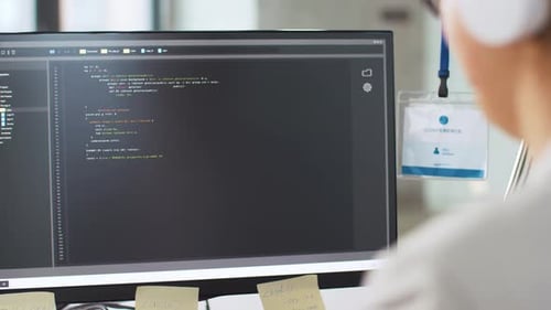 Female programmer works with computer script in modern office environment