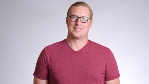 Confident young man smiling brightly in a studio headshot on white background