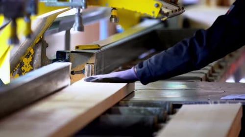 Nahaufnahme der automatisierten Holzbearbeitung beim Bohren leichter Holzbretter