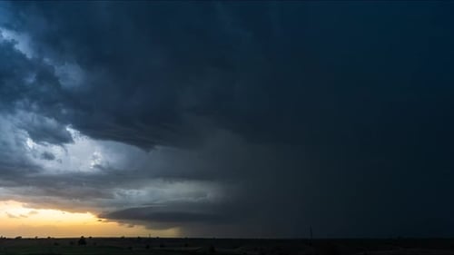 Dramatic Storm Clouds and Sunset Over Rural Landscape