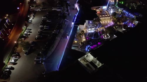 Luzes coloridas no luxuoso local de festas no Algarve, Portugal, à noite, com carros estacionados no P