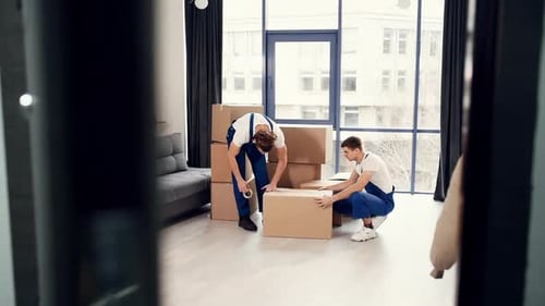 Men in Overalls Packing Cardboard Boxes in Apartment