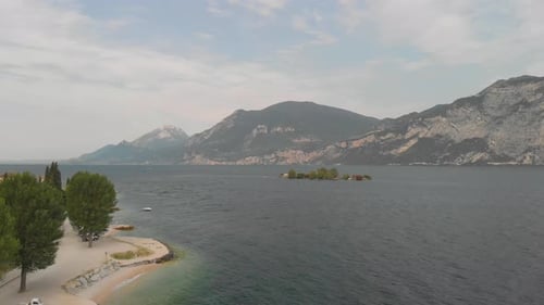 a professional looking aerial at lake Garda, pointing towards the coastline and monte baldo while su
