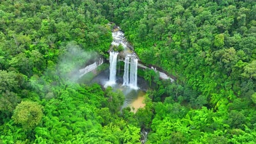 Aerial view over a waterfall in a beautiful tropical forest.