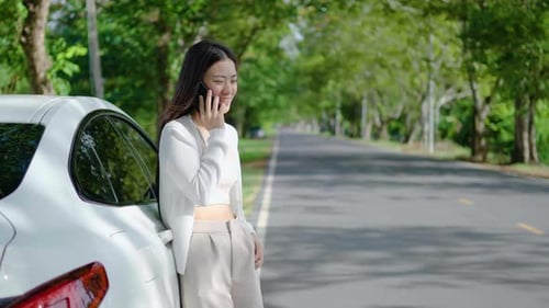 Smiling Woman Talking on Phone Beside Her Car