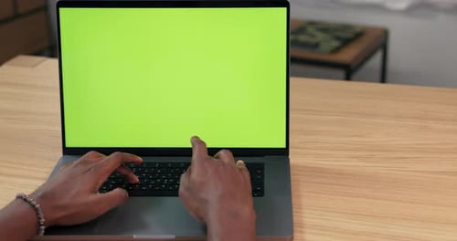Handsome AfricanAmerican Professional Working on Laptop with Green Screen Mock Up in Home Room