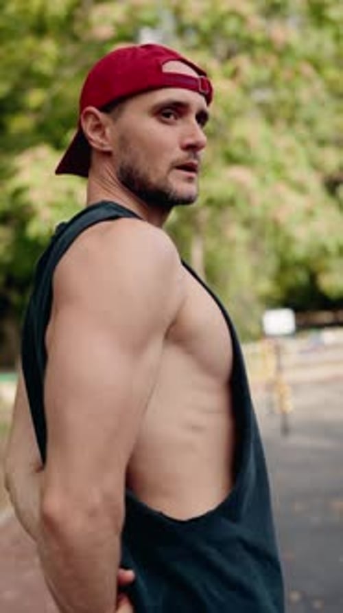 Muscular Man Stretching Before a Workout in an Outdoor Fitness Park