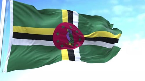 Waving Flag of Dominica Against Blue Sky