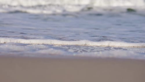 Foam from breaking waves washed up on sandy Sylt beach in Germany