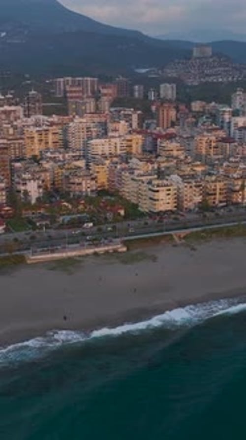 Vertical Video Scenic Sunset Over a Coastal City With Warm Light and the Ocean Horizon in the