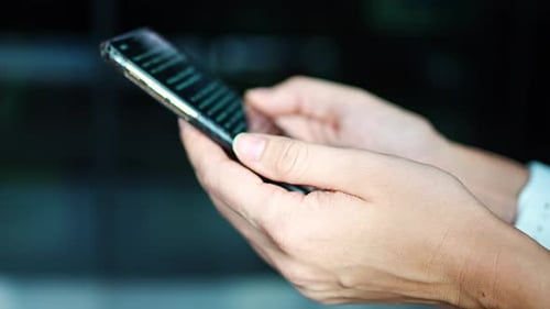 Nahaufnahme der Hand einer Frau, die ein Online-Buch auf ihrem Smartphone liest
