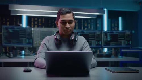 Man Works On Laptop in Data Center